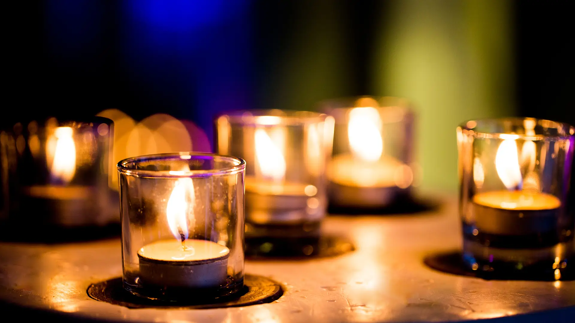 candles burning in darkness over black background