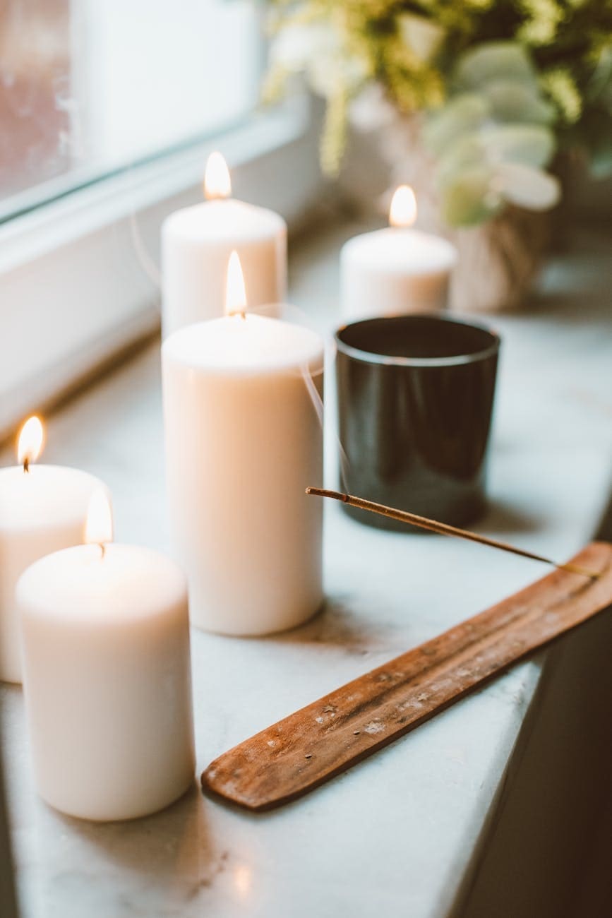 Lit beeswax candles on a table, showcasing handmade, eco-friendly, natural, and non-toxic qualities.